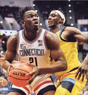  ?? Jessica Hill / Associated Press ?? UConn’s Adama Sanogo looks to shoot as Marquette’s Kur Kuath, right, defends in the first half on Tuesday in Hartford.