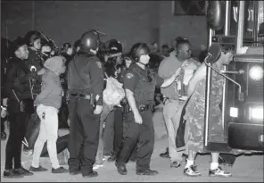  ?? AP/ TONY DEJAK ?? Demonstrat­ors protesting the acquittal of Cleveland police officer Michael Brelo on Saturday are escorted to a bus for transport after their arrest in Cleveland.