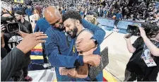  ?? DAVID ZALUBOWSKI THE ASSOCIATED PRESS ?? Nuggets assistant coach Popeye Jones hugs guard Jamal Murray after Game 5 against the L.A. Lakers in Denver on Monday night. Murray scored 32 points despite playing with a strained calf and sank the game-winning basket with 3.6 seconds left in a 108-106 victory. With the win, the Nuggets finished off the Lakers in the best-of-seven series in just five games.