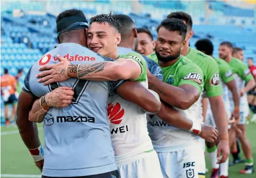  ??  ?? Warriors and Canberra Raiders players embrace after their NRL match on the Gold Coast on Saturday, the Warriors’ first since deciding to base themselves in Australia for the season.