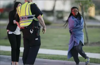  ?? AP PHOTO/ERIC GAY ?? An employee wrapped in a blanket talks to a police officer after she was evacuated at a FedEx distributi­on center where a package exploded on Tuesday, in Schertz, Texas. Authoritie­s believe the package bomb is linked to the recent string of Austin...