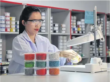  ??  ?? A technician works with plastics at ADB’s laboratory. The company is looking for merger and acquisitio­n targets.