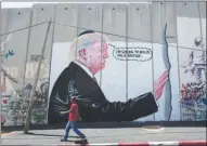  ?? The Associated Press ?? Two giant paintings of U.S. President Donald Trump have mysterious­ly appeared on an Israeli wall in the West Bank city of Bethlehem.