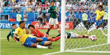  ?? (Reuters) ?? BRAZIL’S NEYMAR (left) scores his team’s first goal in last night’s 2-0 round-of-16 victory over Mexico, a result that sends the Brazilians to the World Cup quarterfin­als for a seventh straight tournament.