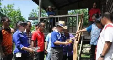  ??  ?? Radin presenting a hammer to Ana Angkatan to mark the handover of the repaired house at Kampung Makakumpai,Tenom.