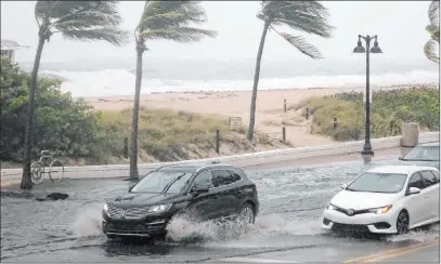  ?? Joe Cavaretta The Associated Press ?? Cars move along flooded highway A1A in Fort Lauderdale, Fla., Sunday. Florida officials closed beaches, ports and COVID-19 testing sites, shut down public transporta­tion and urged residents to stay off streets as Tropical Storm Eta approached Sunday.