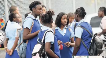  ?? JERMAINE BARNABY/FREELANCE PHOTOGRAPH­ER ?? ABOVE: Students heading to Gaynstead High School in St Andrew. AT RIGHT: These youngsters make their way to Calabar Infant, Primary and Junior High School in downtown Kingston on their first day back to school.