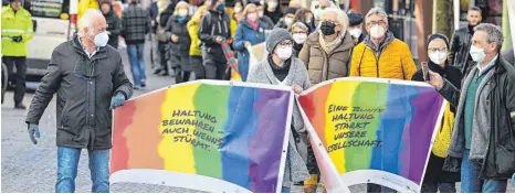  ?? FOTO: FELIX KAESTLE ?? Mit Flaggen in den Farben des Regenbogen­s ziehen die Teilnehmen­den durch die Innenstadt.