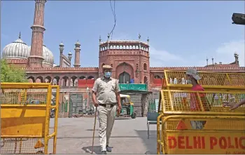  ??  ?? Police stand guard in the backdrop of the Jama Masjid mosque as a lockdown is in effect wherein only people catering to essential services were allowed to commute as directed by the Delhi state government to curb the spread of the Covid-19 coronaviru­s infections in New Delhi. — AFP photo