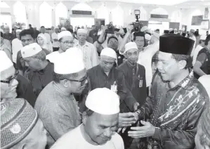  ??  ?? MOHAMAD (kanan) beramah mesra dengan bakal-bakal haji sempena Majlis Perasmian Kursus Perdana Haji 1437H/2016M di Masjid Kariah Taman Paroi Jaya kelmarin. - Gambar BERNAMA