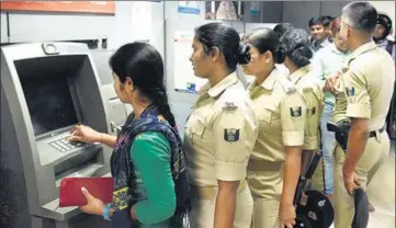  ?? SANTOSH KUMAR/ HT PHOTO ?? Police personnel queue up with others at an ATM in Patna on Tuesday.