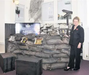  ??  ?? Cath Holmes, daughter of Walter Holmes, with the trench and interactiv­e module inside Accrington Town Hall