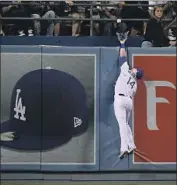  ?? John McCoy Getty Images ?? ENRIQUE HERNANDEZ can’t catch a homer by Pat Valaika, the first of three solo shots Colorado hit.