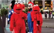  ?? — AP ?? Costumed characters at Times Square search for customers in New York on Thursday.