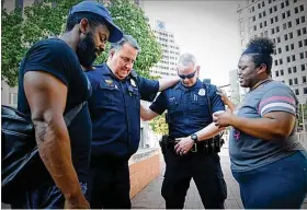  ?? MARSHALL GORBY / STAFF ?? Police Officer Will Davis, Sgt. Chad Knight, Natasha Hunter and a man who wished not to be identified pray together at Courthouse Square in downtown Dayton after a footwashin­g ceremony.