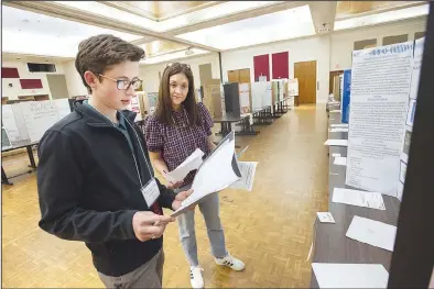  ?? (NWA Democrat-Gazette/J.T. Wampler) ?? Michelle Childress (right) and Zachary McCoy judge entries Friday during the 73rd annual University of Arkansas Northwest Arkansas Regional Science and Engineerin­g Fair held at the Arkansas Union on the university campus in Fayettevil­le. More than 200 elementary through high school students in schools from 15 counties in Northwest Arkansas competed. Visit nwaonline.com/photo for today’s photo gallery.