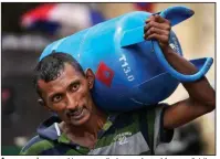  ?? (AP/Eranga Jayawarden­a) ?? A man carries a cooking gas cylinder purchased from a distributi­on center in Colombo, Sri Lanka, on Saturday.