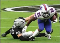  ?? ETHAN MILLER/GETTY IMAGES ?? Devin Singletary (26) of the Bills runs with the ball against Erik Harris (25) of the Raiders on Sunday in Las Vegas, Nevada.