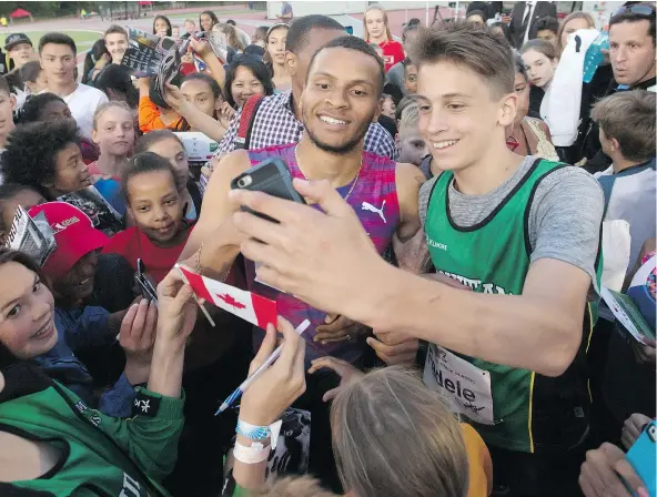  ?? — THE CANADIAN PRESS FILES ?? Andre De Grasse, centre, is mobbed after racing to a first-place finish during the 100-metre race at the Harry Jerome Internatio­nal Track Classic in Coquitlam on June 28, 2017. De Grasse will return this year for his third consecutiv­e visit to the...