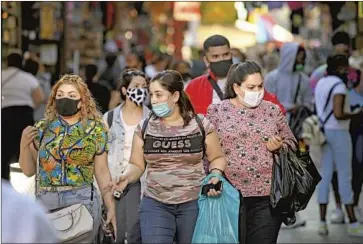  ?? Wally Skalij Los Angeles Times ?? OFFICIALS with the state Department of Public Health say double masking “is an effective way to improve fit and filtration.” Above, shoppers stroll in the Santee Alley area of downtown Los Angeles in November.