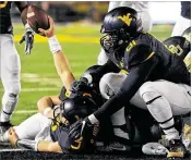  ?? JUSTIN BERL / GETTY IMAGES ?? Mountainee­rs senior quarterbac­k Skyler Howard (left, on ground) ranks fourth in the Big 12 in passer rating. He has thrown for 3,194 yards and 26 TDs.