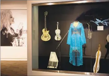  ?? Photograph­s by Dania Maxwell Los Angeles Times ?? COSTUMES AND instrument­s, such as these from a 2009 concert, are part of a new Dolly Parton exhibit.