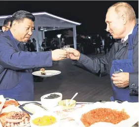  ??  ?? Hail to the chef: Presidents Vladimir Putin and Xi Jinping make pancakes at the Eastern Economic Forum in Vladivosto­k, Russia. Photo: Reuters