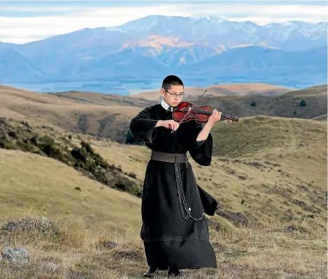  ??  ?? Although he plays his violin high up in the South Canterbury hills at the back of Geraldine, 19-year-old Brother Benedict, main image, prefers a life of austerity to a profession­al music career. Right, Brother Raphael and Father Anthony pray at the Mt Saint Joseph site where the order wants to build a monastery complex just up from where they’re building new cells at an existing site.