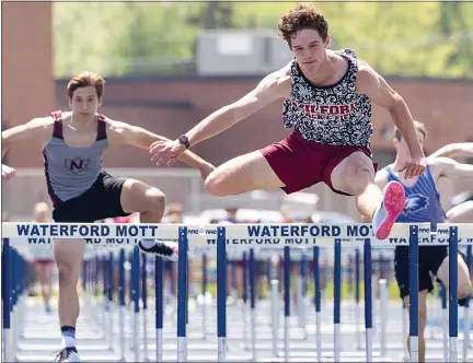  ?? TIMOTHY ARRICK PHOTOS — FOR MEDIANEWS GROUP ?? Milford’s Brayden Kennedy, right, took first place in the 110-meter hurdles with a time of 14.78seconds to help the Mavericks boys team take the Lakes Valley Conference championsh­ip on Saturday at Waterford Mott High School in Waterford. MIlford’s girls also won.