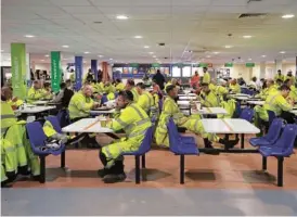  ?? AP PHOTO/KIN CHEUNG ?? Workers have lunch Oct. 11 at the canteen of the constructi­on site of Hinkley Point C nuclear power station in Somerset, England.