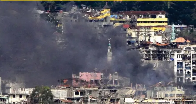  ?? (RICHEL V. UMEL) ?? FINAL PUSH. The minaret of Bato Mosque is shrouded in smoke after an FA-50 airstrike Tuesday afternoon, September 26. Government forces are said to be conducting a final push against the ISIS-linked extremists in Marawi City. At least 12 extremists and...