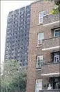  ?? KIRSTY WIGGLESWOR­TH/AP ?? A woman looks from her balcony near the remains of Grenfell Tower in London.