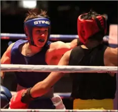  ?? JULIA MALAKIE — LOWELL SUN ?? Hunter Dickinson of Lewiston, Maine, left, won by decision over Jonathan Delgado of Milford in a 147-pound bout.