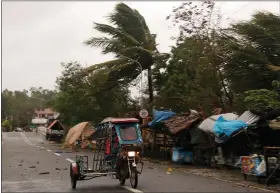  ?? SIMVALE SAYAT — THE ASSOCIATED PRESS ?? A man drives his tricycle along a road as strong winds caused by typhoon Vongfong hit Catbalogan city in eastern Philippine­s on Thursday.