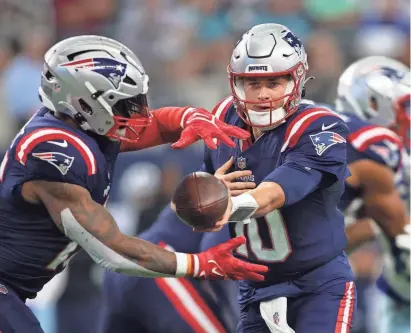  ?? ?? Patriots quarterbac­k Mac Jones hands the ball off to running back Ezekiel Elliott (15) in last week’s game at Dallas. New England’s offense will need to play a much better game in order to bounce back on Sunday against New Orleans.