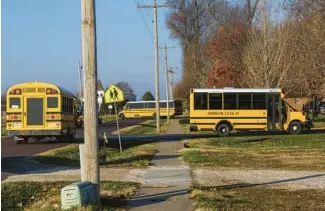  ?? ?? Buses from school districts throughout an eight-county region of rural Illinois bring students to the Garrison School in Jacksonvil­le on a morning in November.