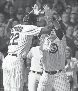  ?? DAVID BANKS / USA TODAY SPORTS ?? Cubs catcher Miguel Montero (right) is greeted by Jason Heyward after hitting a two-run home run off Brewers starter Jimmy Nelson in the fourth inning Tuesday night.