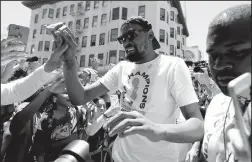  ?? JANE TYSKA/TRIBUNE NEWS SERVICE ?? The Golden State Warriors' Kevin Durant greets fans during the team's championsh­ip parade in downtown Oakland on Tuesday.