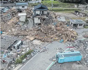  ?? CARL COURT GETTY IMAGES ?? Overturned vehicles lie next to a ruined house that is surrounded by debris and driftwood after the nearby Kuma River flooded during torrential rain, on Wednesday in Kuma, Japan.