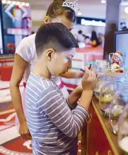  ??  ?? Dads and kids busy themselves with decorating their own Christmas glitter globes to take home from the Holiday Fair.