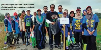  ??  ?? JABAR (tengah) bersama sukarelawa­n dan penduduk kampung membersihk­an kawasan sawah.