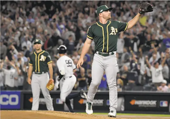  ?? Bill Kostroun / Associated Press ?? A’s pitcher Liam Hendriks, who began the game as a non-traditiona­l opener, grimaces after giving up a two-run home run to the Yankees’ Aaron Judge (rear).