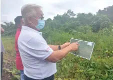  ?? — Photo by Sarawak Public Communicat­ions Unit ?? Sikie studies the map that outlines the new site for a longhouse in Kakus constituen­cy.