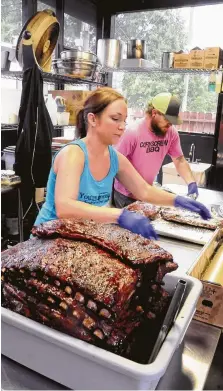  ?? David Hopper ?? Nichole and Will Buckman wrap to go barbecue-rib orders at their Corkscrew BBQ in Spring. One or both are usually on site.