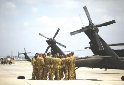  ?? (Amir Cohen/Reuters) ?? AMERICAN SOLDIERS gather next to Black Hawk helicopter­s during a dress rehearsal of the arrival ceremony for US President Donald Trump at Ben-Gurion Airport in May 2017.