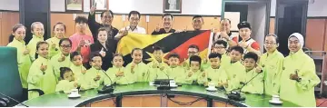  ??  ?? Karim (seventh left), WFS president Allen Wong (eighth left), WFS deputy president James Ting (sixth left), MSNS wushu coordinato­r Thomas Chia (third right), Sarawak athletes and officials gesture during the flag presentati­on at Karim’s office at...