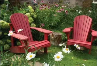  ?? PHOTOS BY KATHY RENWALD, SPECIAL TO THE HAMILTON SPECTATOR ?? A friendly front yard with Muskoka chairs set in a little clearing and surrounded by perennials.