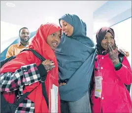  ?? AP PHOTO ?? Halima Mohamed embraces her daughters Muzamil Shalle, 14, left, and Miski Shalle, 11, right, after their arrival from Somalia at John F. Kennedy Internatio­nal Airport in New York.