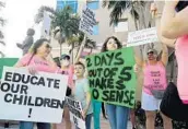  ?? AMY BETH BENNETT/SOUTH FLORIDA SUN SENTINEL ?? Anna Warburton, of Cooper City, with her children, Grant, 7, and Ava, 12, protest outside of the Broward school board headquarte­rs in Fort Lauderdale on June 30.