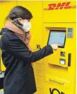  ?? FOTO: DPA ?? Eine Post-Mitarbeite­rin bedient eine neue Poststatio­n. Der gelbe Container ist eine Erweiterun­g der schon bekannten Packstatio­n.
